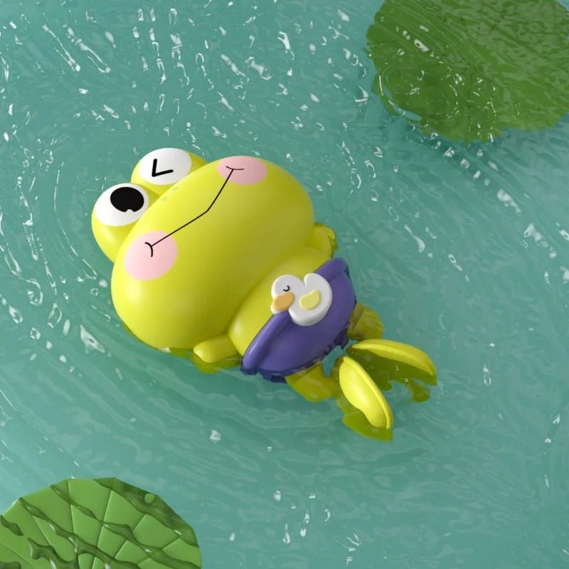 Jouet de bain en forme de grenouille, couleur verte, flottant dans l'eau avec un petit canard sur son dos.