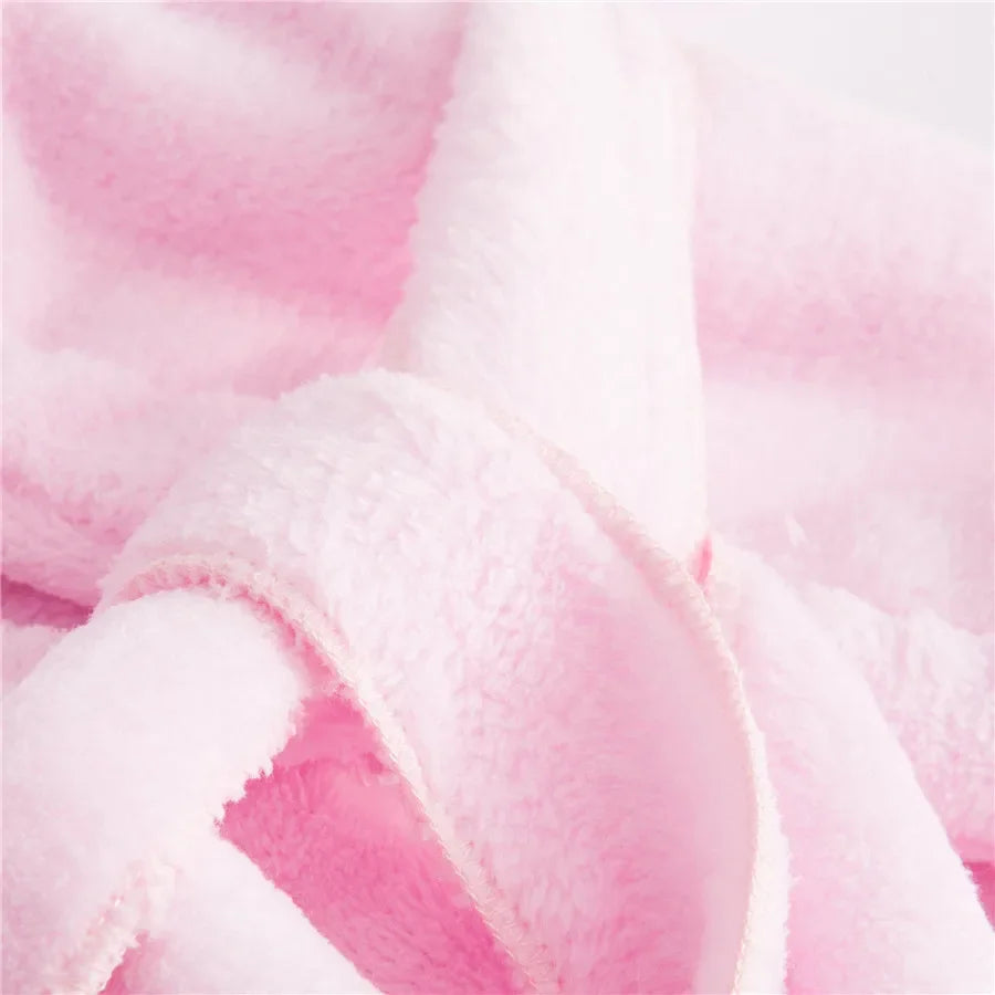 Bébé enveloppé dans une cape de bain rose moelleuse après le bain