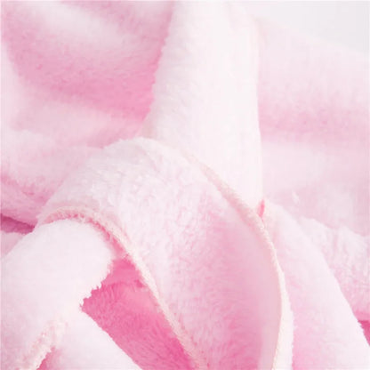 Bébé enveloppé dans une cape de bain rose moelleuse après le bain