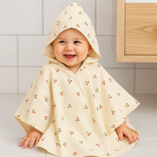bebe sourit grâce à sa cape de bain bebe