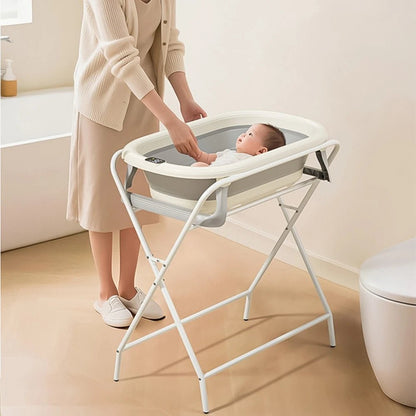  maman observe son bebe ndans la baignoire pliable. bebe